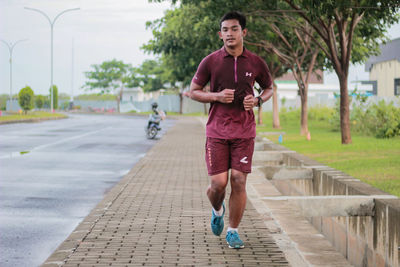 Full length portrait of man standing on footpath