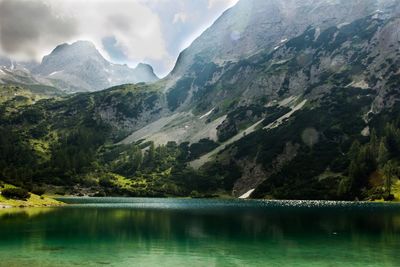 Scenic view of lake by mountains against sky