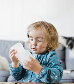 Cute girl holding container at home