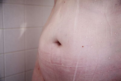 Midsection of woman bathing in bathroom