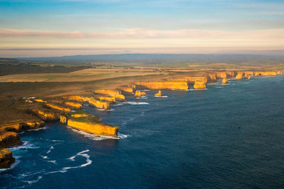 High angle view of townscape by sea against sky during sunset