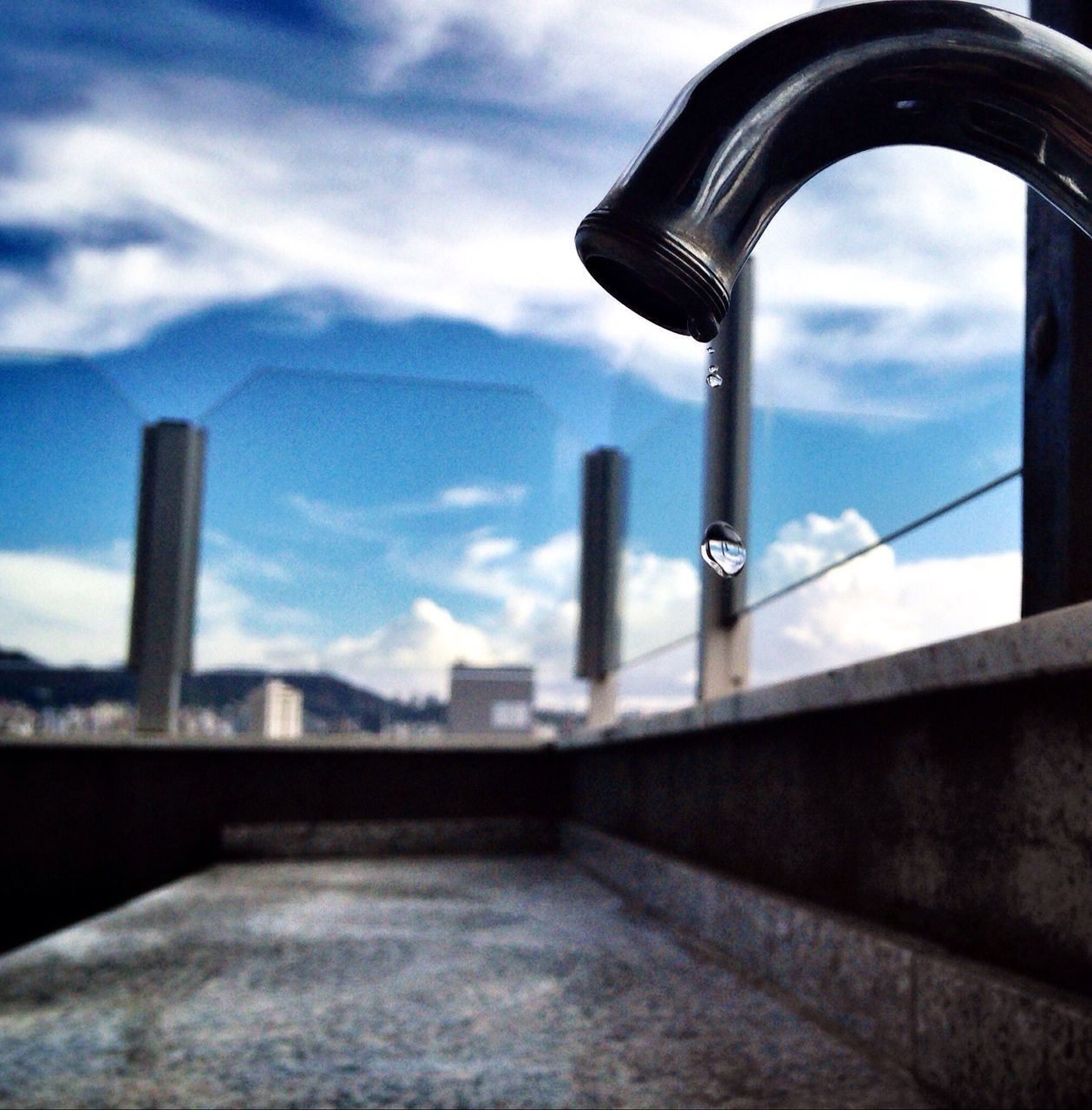 sky, architecture, built structure, building exterior, cloud - sky, cloud, low angle view, cloudy, metal, railing, blue, day, tower, outdoors, no people, focus on foreground, focus on background, city, building, protection