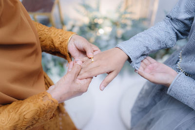 Installation of gold engagement ring on the finger