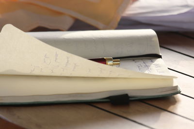 Close-up of pen on open diary over table