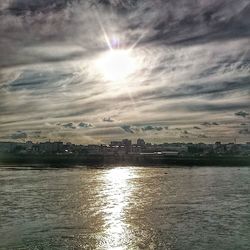Scenic view of river against cloudy sky