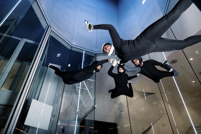 Athletes holding each others hands flying in wind tunnel