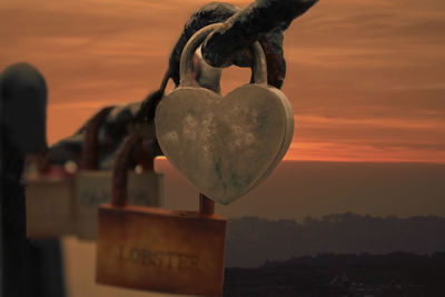 Close-up of padlocks on heart shape against sky