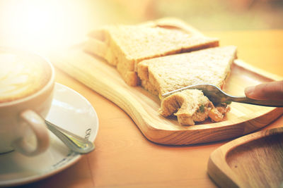 Cropped hand having breakfast at table