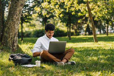 Young man using mobile phone in park