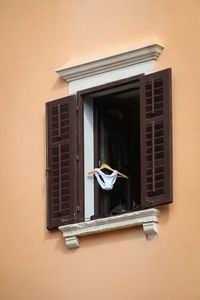 Low angle view lingerie on coathanger at window on building