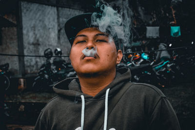 Portrait of young man smoking outdoors