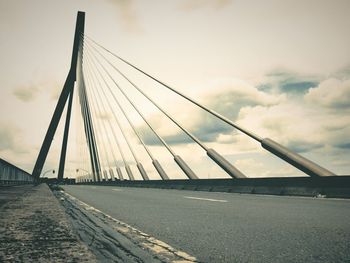 View of suspension bridge against cloudy sky