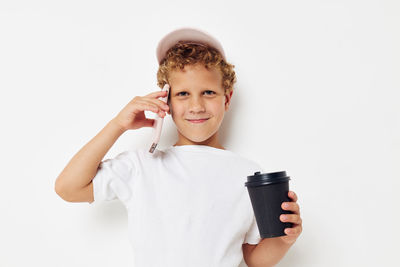 Happy boy talking on smart phone against white background