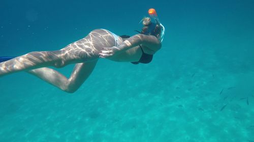 Full length of young woman swimming in sea