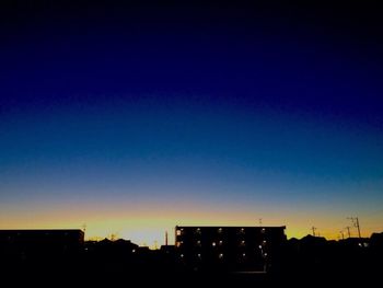 Silhouette buildings against clear sky at night