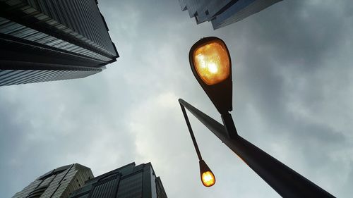 Low angle view of illuminated building against cloudy sky