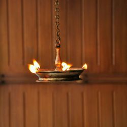 Close-up of oil diya against wall