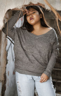 Portrait of woman standing against wall