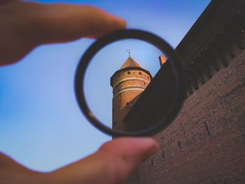 Cropped hand holding ring against castle