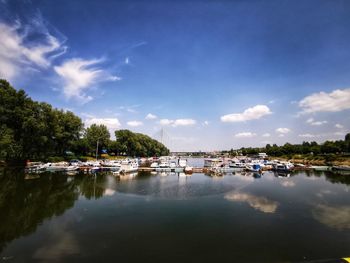 Sailboats moored in lake against sky