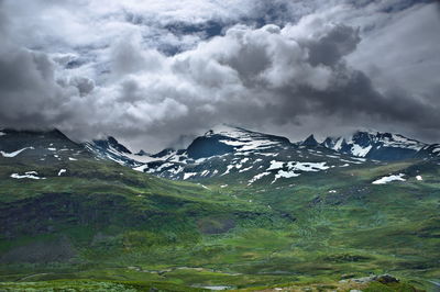 Scenic view of mountains against cloudy sky during winter