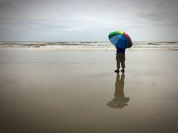 Full length of man standing on beach against sky