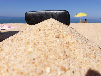 Close-up of person on sand at beach against sky