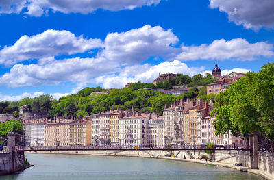 Bridge over river amidst buildings in city