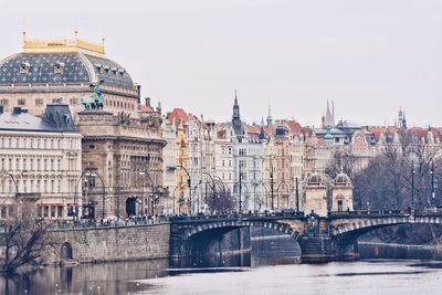 Bridge over river in city against sky