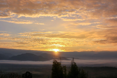 Scenic view of silhouette mountains against orange sky