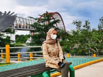 Low angle view of woman standing on railing