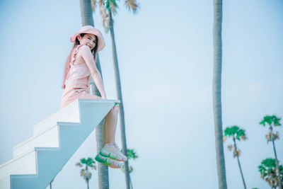 Low angle view of woman standing against sky