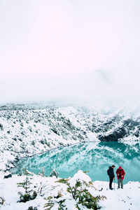 People standing near a glacial lake