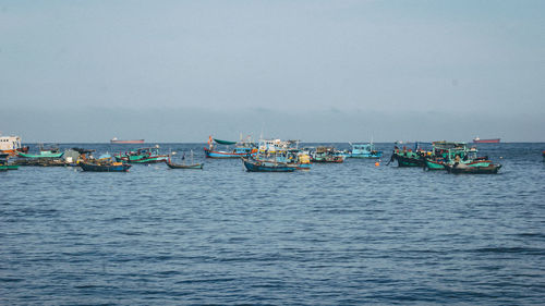 Boats in sea against clear sky