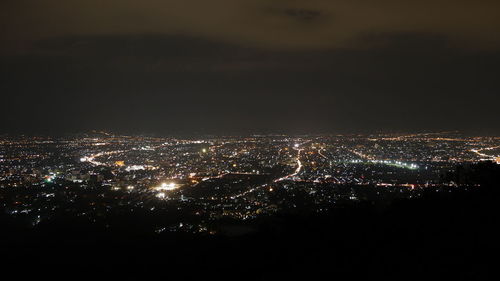 Illuminated cityscape against sky at night