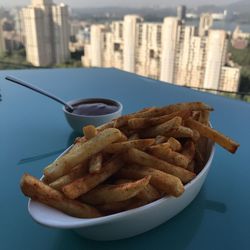 Close-up of meat and fries on table in city