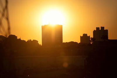 Silhouette buildings against sky during sunset