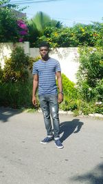 Full length portrait of young man standing against tree