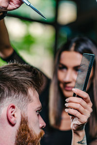 Hairdresser cutting man hair at salon