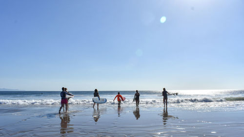 People at beach against sky