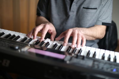 Midsection of man playing piano