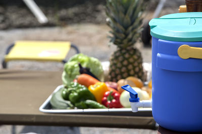 Water container by various fruits and vegetables on table