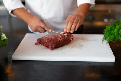 Close-up of person preparing food on cutting board