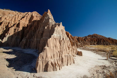 Panoramic view of rocky mountains against clear blue sky