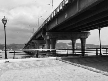 Bridge over river against cloudy sky