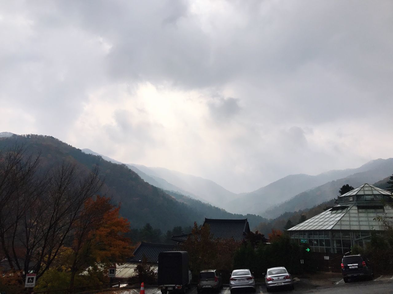 car, mountain, sky, transportation, building exterior, land vehicle, outdoors, built structure, cloud - sky, day, nature, beauty in nature, architecture, tree, no people, scenics, road, mountain range, city