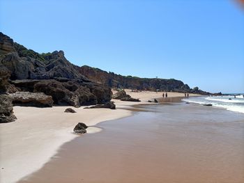 Rock formations on beach against clear blue sky in calas de roche - cádiz - spain