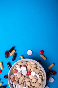 Directly above shot of pills in plate on blue background