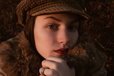 Close-up portrait of young woman wearing cap