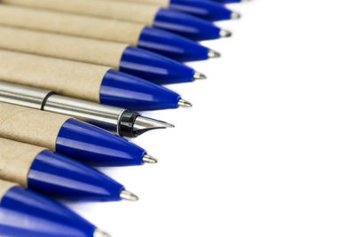 Close-up of blue colored pencils on white table